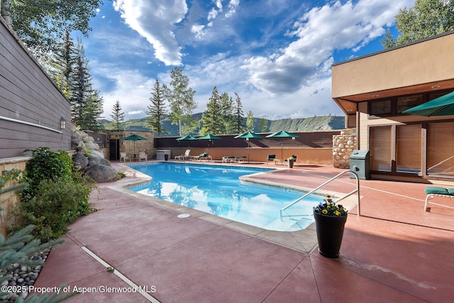 view of swimming pool with a mountain view, a patio, and a grill