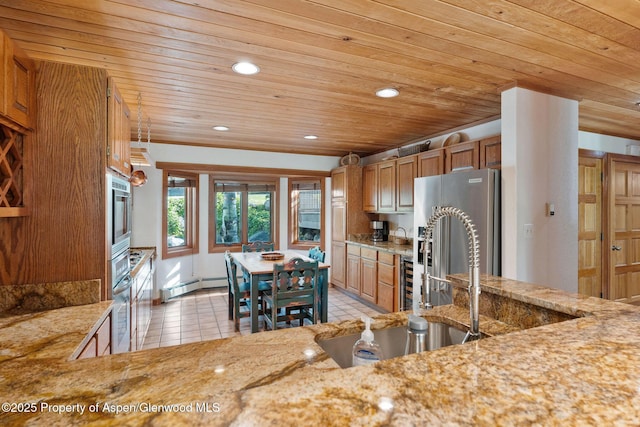 kitchen with a baseboard heating unit, light tile patterned floors, light stone counters, wood ceiling, and stainless steel appliances