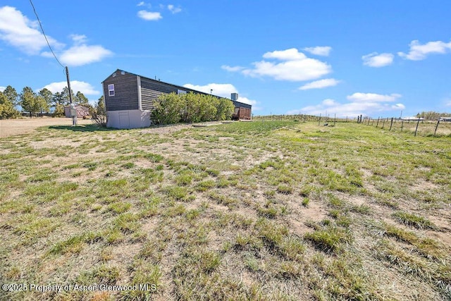 view of yard with fence and a view of rural / pastoral area