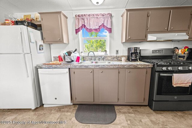 kitchen with white appliances, under cabinet range hood, a sink, light countertops, and gray cabinetry
