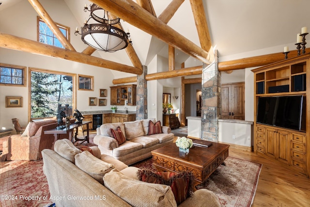 living room featuring high vaulted ceiling, light hardwood / wood-style floors, and beverage cooler