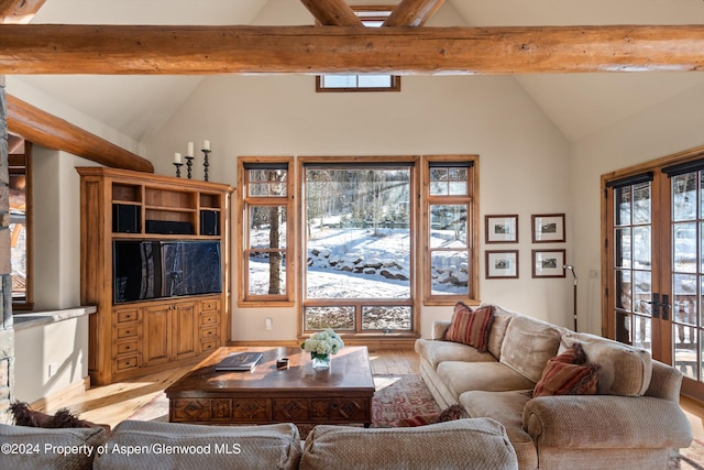 living room featuring vaulted ceiling with beams, light wood-type flooring, and french doors