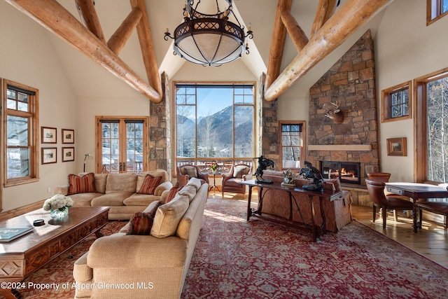 living room featuring a mountain view, high vaulted ceiling, a fireplace, and beamed ceiling