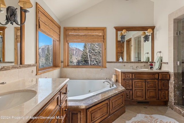 bathroom with vanity, vaulted ceiling, tile walls, tile patterned flooring, and shower with separate bathtub