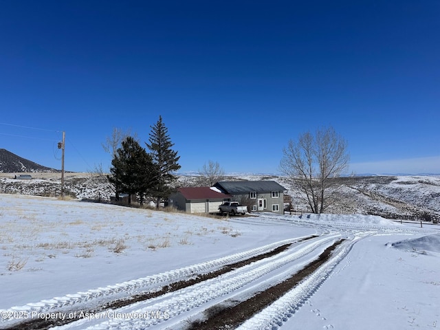 yard layered in snow with a mountain view