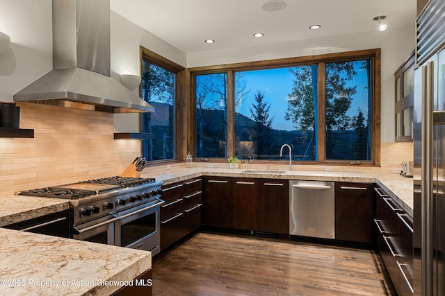 kitchen featuring sink, premium appliances, island exhaust hood, light stone countertops, and dark brown cabinets