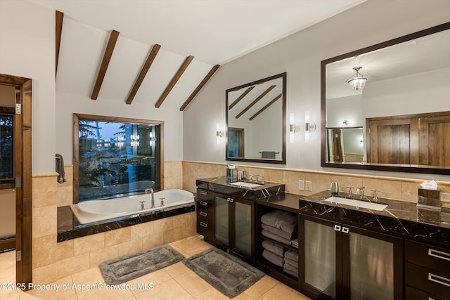 bathroom featuring lofted ceiling with beams, tiled bath, tile walls, vanity, and tile patterned floors