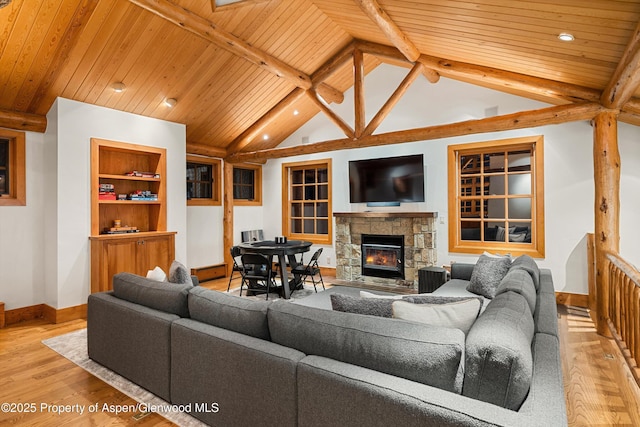 living room featuring built in features, vaulted ceiling with beams, a fireplace, light hardwood / wood-style floors, and wooden ceiling