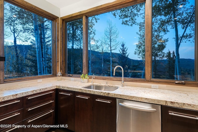 kitchen with dishwasher, sink, dark brown cabinets, and a mountain view