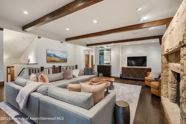 living room featuring beamed ceiling, dark wood-type flooring, and a fireplace