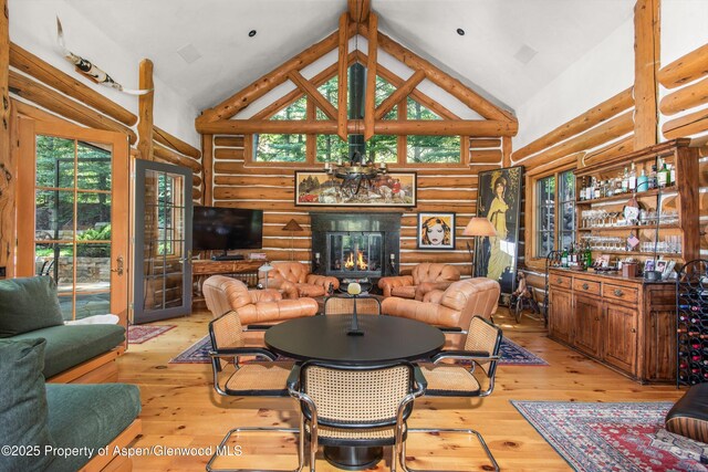 408 Gerbaz Way, Snowmass, CO 81654 - living area with high vaulted ceiling, rustic walls, plenty of natural light, light wood-style floors, and a glass covered fireplace