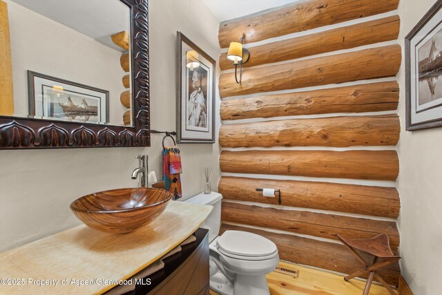 408 Gerbaz Way, Snowmass, CO 81654 - half bathroom featuring vanity, rustic walls, and wood finished floors