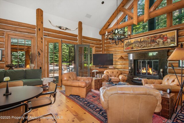 408 Gerbaz Way, Snowmass, CO 81654 - living room featuring log walls, hardwood / wood-style floors, high vaulted ceiling, and a premium fireplace