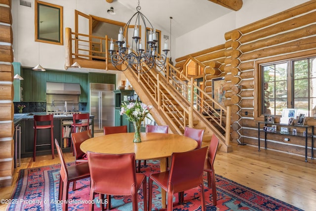 408 Gerbaz Way, Snowmass, CO 81654 - dining space featuring rustic walls, wood finished floors, stairway, a high ceiling, and a chandelier