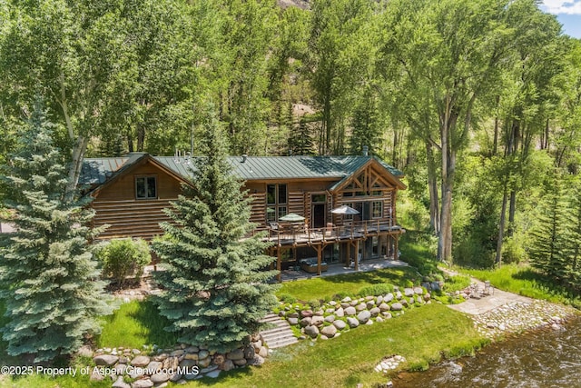 408 Gerbaz Way, Snowmass, CO 81654 - rear view of house featuring a standing seam roof, log siding, a wooden deck, a metal roof, and a patio area