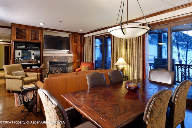 dining area featuring wood-type flooring and crown molding