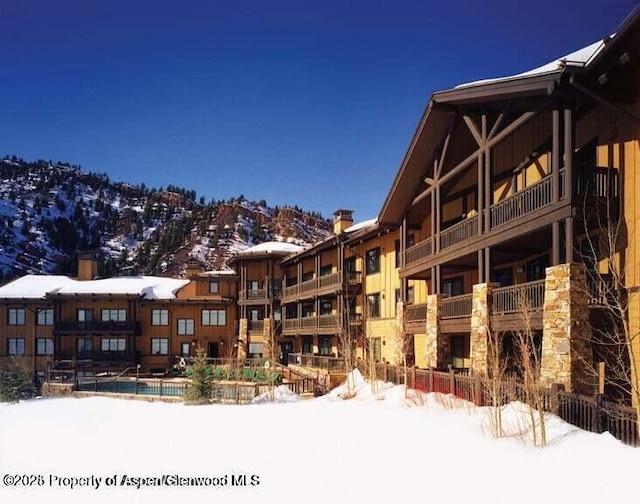 snow covered building featuring a mountain view