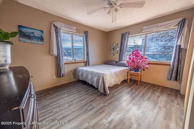 bedroom featuring hardwood / wood-style floors, a textured ceiling, and ceiling fan