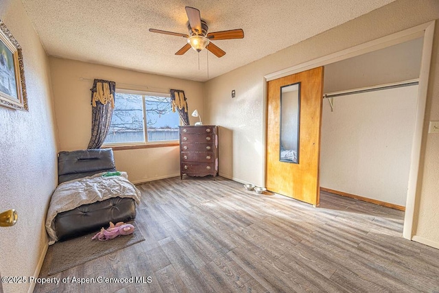 unfurnished room featuring ceiling fan, wood-type flooring, and a textured ceiling