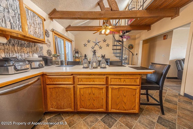 kitchen featuring beam ceiling, kitchen peninsula, ceiling fan, and dishwasher