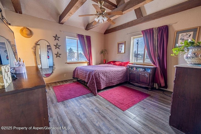 bedroom with lofted ceiling with beams, ceiling fan, dark hardwood / wood-style flooring, and a textured ceiling