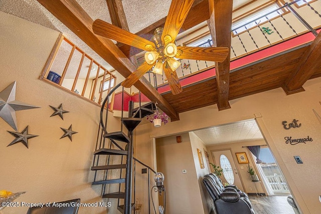 living room with beam ceiling, ceiling fan, and wooden ceiling