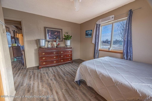 bedroom with hardwood / wood-style floors, a textured ceiling, and ceiling fan