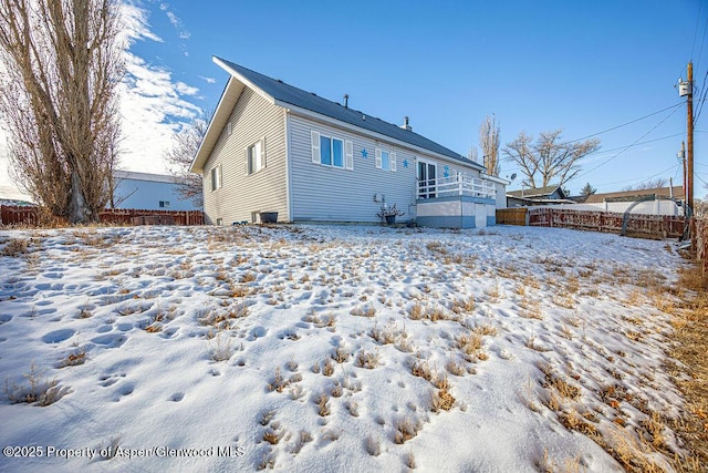 snow covered house with central air condition unit