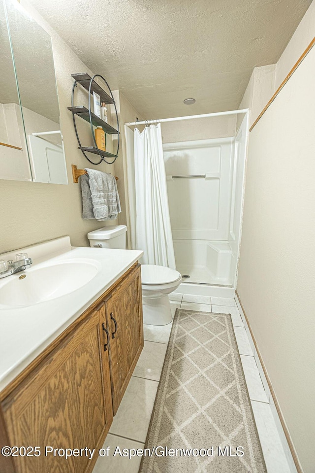 bathroom with tile patterned floors, a shower with curtain, vanity, and a textured ceiling