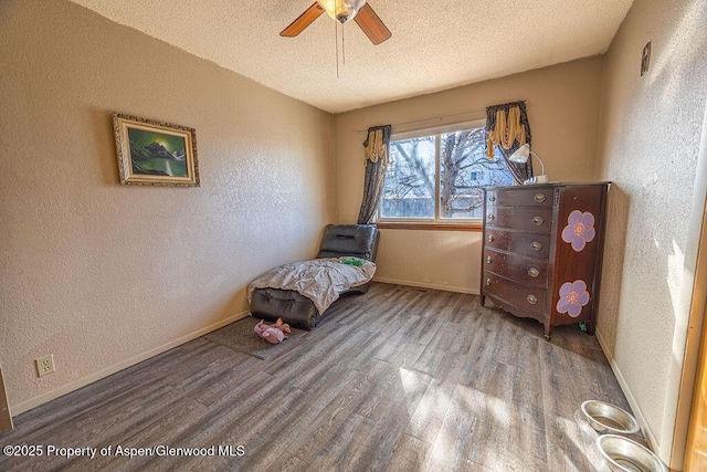 bedroom with hardwood / wood-style floors, ceiling fan, and a textured ceiling