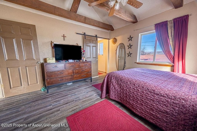 bedroom featuring hardwood / wood-style floors, vaulted ceiling with beams, ceiling fan, and a barn door