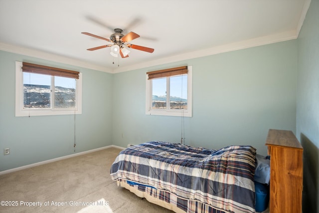 carpeted bedroom with ceiling fan, crown molding, and a mountain view