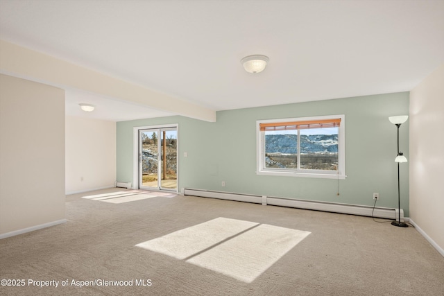 empty room featuring light carpet, beamed ceiling, and a baseboard heating unit