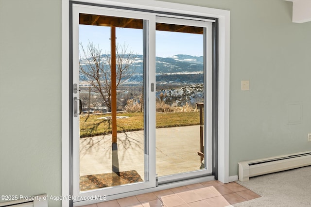 entryway featuring light tile patterned floors, baseboard heating, and a water and mountain view