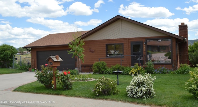 view of front of property with a garage and a front lawn