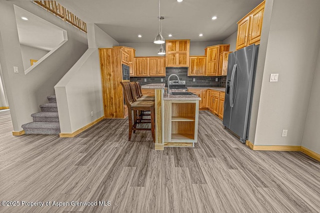 118 Highland Dr, Craig, CO 81625 - kitchen with appliances with stainless steel finishes, light wood-type flooring, recessed lighting, tasteful backsplash, and an island with sink