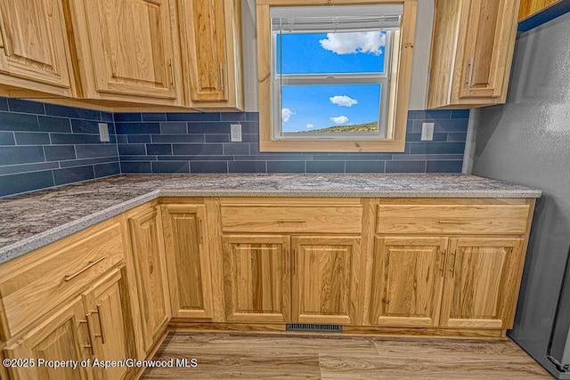 118 Highland Dr, Craig, CO 81625 - kitchen featuring backsplash, light wood-style flooring, and freestanding refrigerator