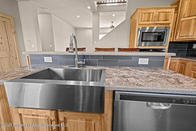 118 Highland Dr, Craig, CO 81625 - kitchen with appliances with stainless steel finishes, decorative backsplash, a ceiling fan, and light stone counters