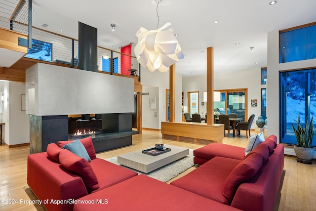 living room with a towering ceiling and light hardwood / wood-style flooring