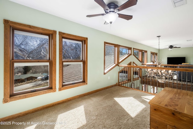 interior space with ceiling fan, visible vents, and baseboards