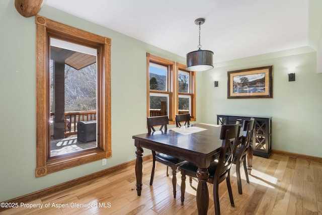 dining room featuring light wood-style flooring and baseboards