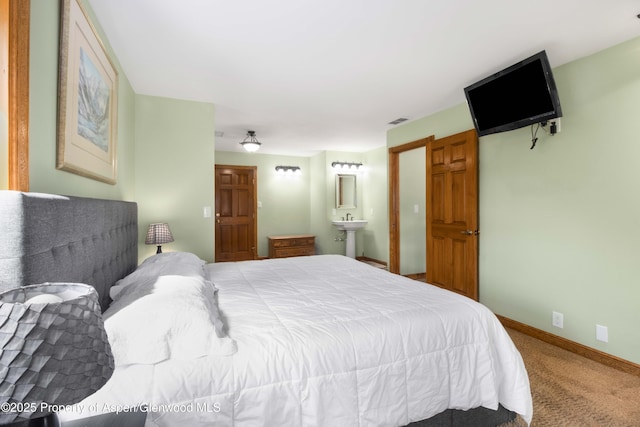 carpeted bedroom featuring visible vents, connected bathroom, and baseboards