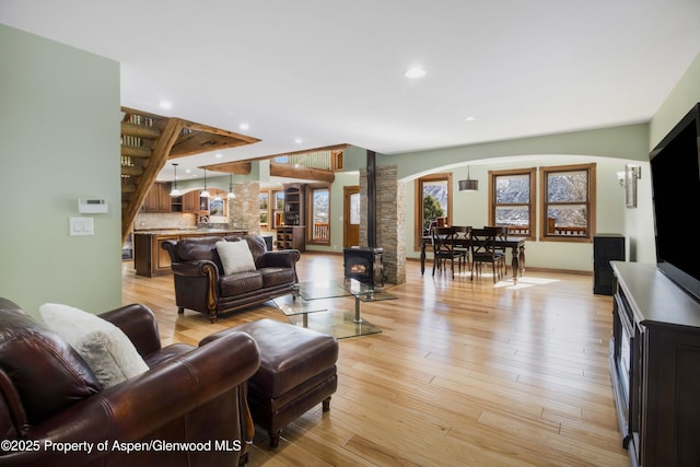 living area with light wood-type flooring, a wood stove, and recessed lighting