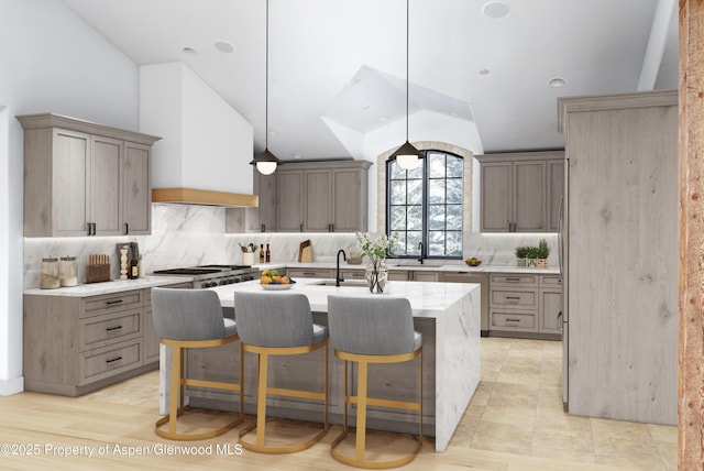 2908 Juniper Hill Dr, Aspen, CO 81611 - kitchen featuring a kitchen island with sink, tasteful backsplash, lofted ceiling, a kitchen breakfast bar, and pendant lighting