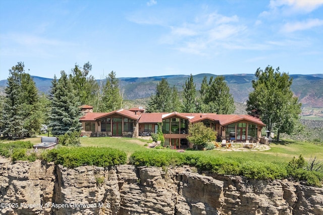 2908 Juniper Hill Dr, Aspen, CO 81611 - back of house featuring a lawn, a mountain view, and a patio area