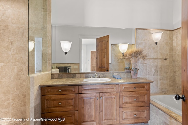 2908 Juniper Hill Dr, Aspen, CO 81611 - bathroom featuring vanity, tiled tub, and tile walls