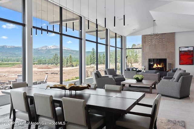 6890 E Sopris Creek Rd, Snowmass, CO 81654 - living area featuring a mountain view, a wall of windows, high vaulted ceiling, and a fireplace