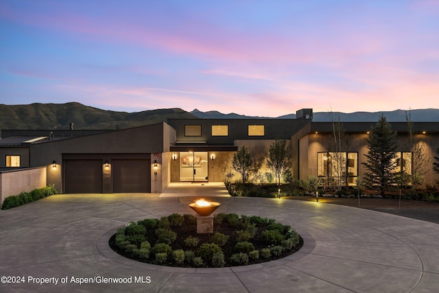 6890 E Sopris Creek Rd, Snowmass, CO 81654 - contemporary house with curved driveway, a mountain view, stucco siding, and a garage