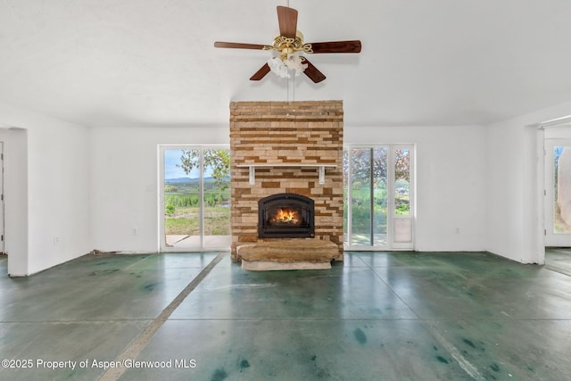 40889 County Road 76a, Hayden, CO 81639 - unfurnished living room featuring healthy amount of natural light, concrete flooring, a large fireplace, and ceiling fan