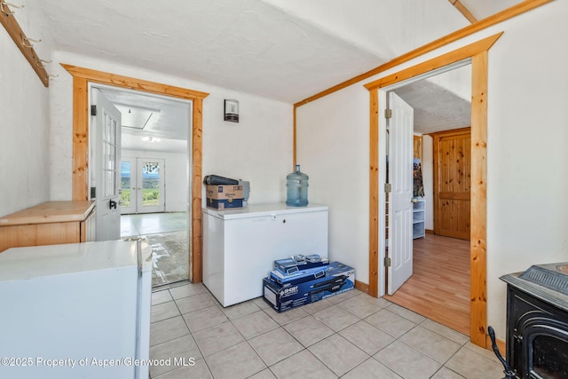 40889 County Road 76a, Hayden, CO 81639 - kitchen with light tile patterned floors, a wood stove, freestanding refrigerator, and light countertops